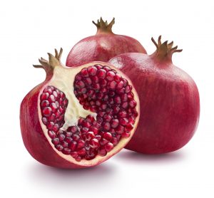 Two whole and one half of pomegranate isolated on white backgrou